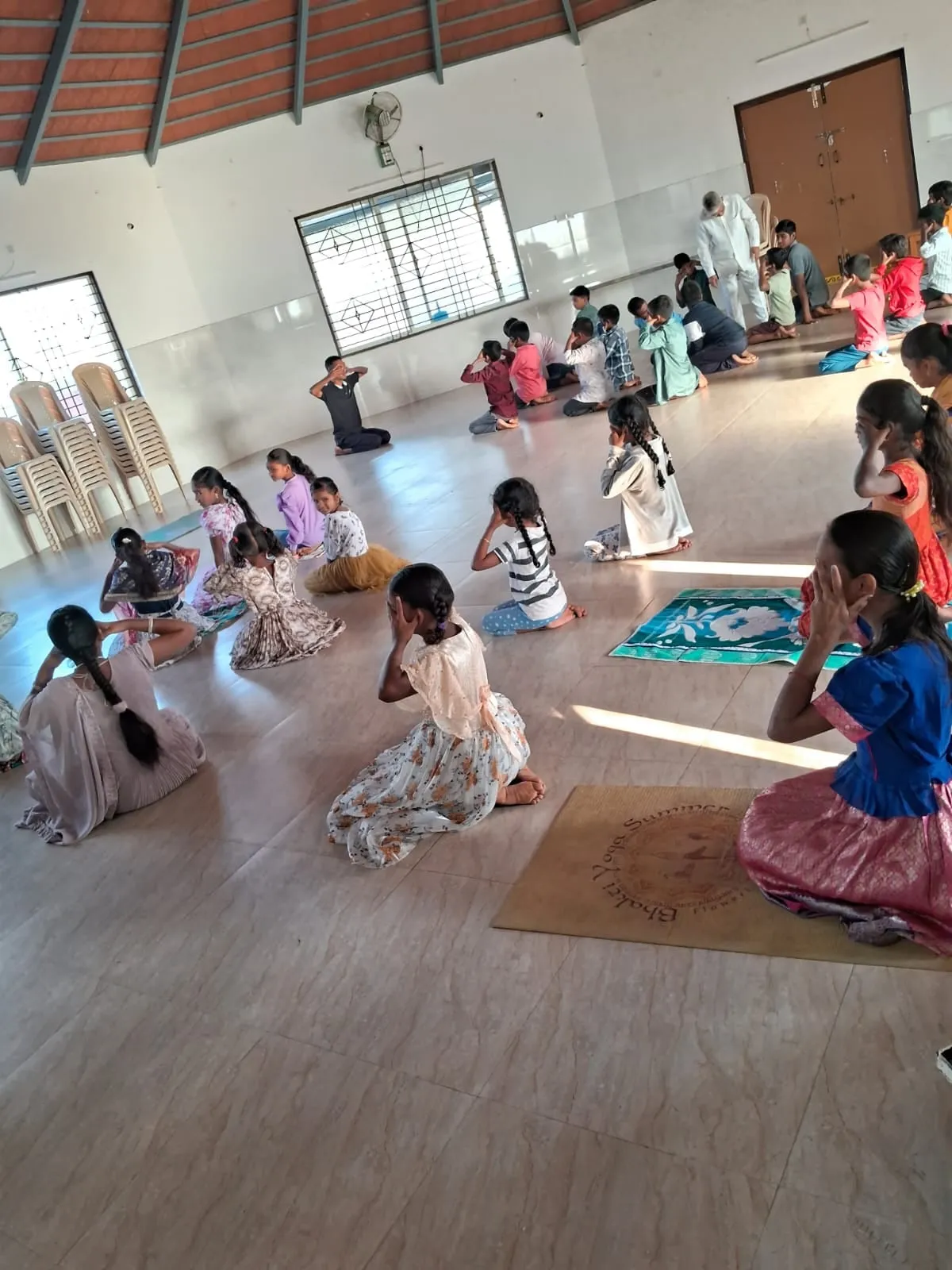 Children seated on the floor of the Kuteer hall during evening tuition