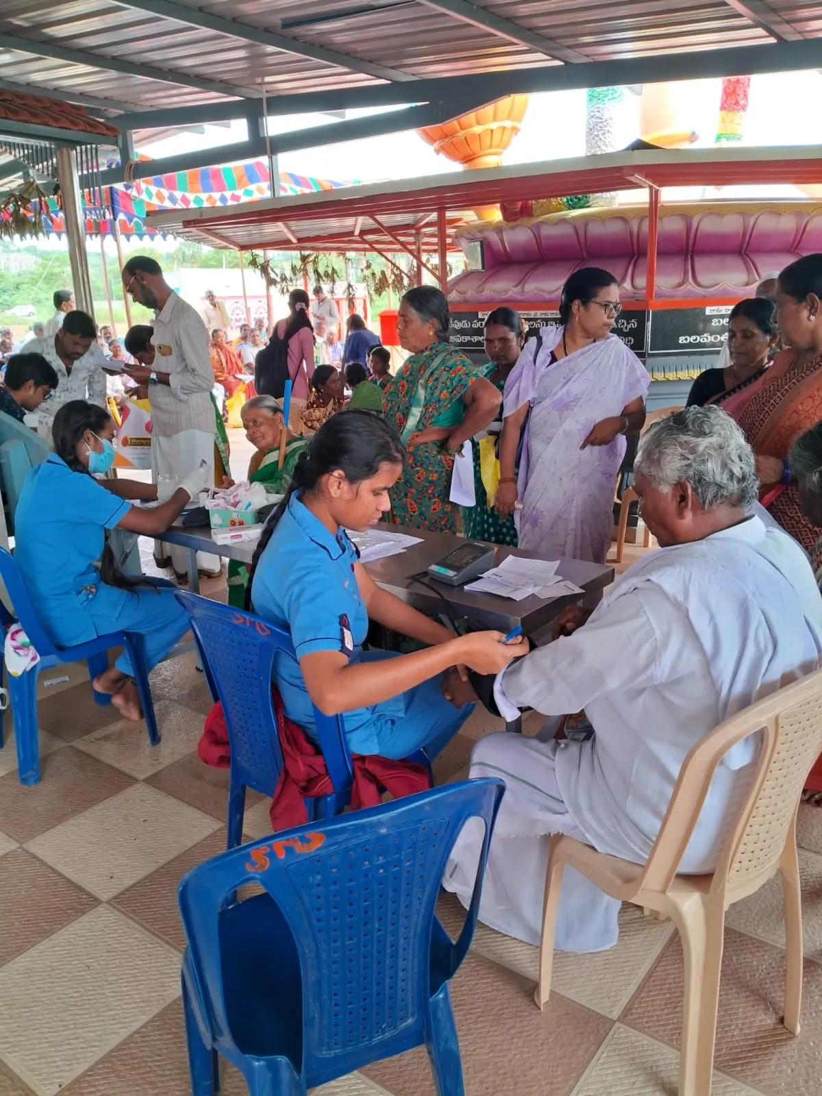 The camp hall busy with patients, volunteers and medical staff