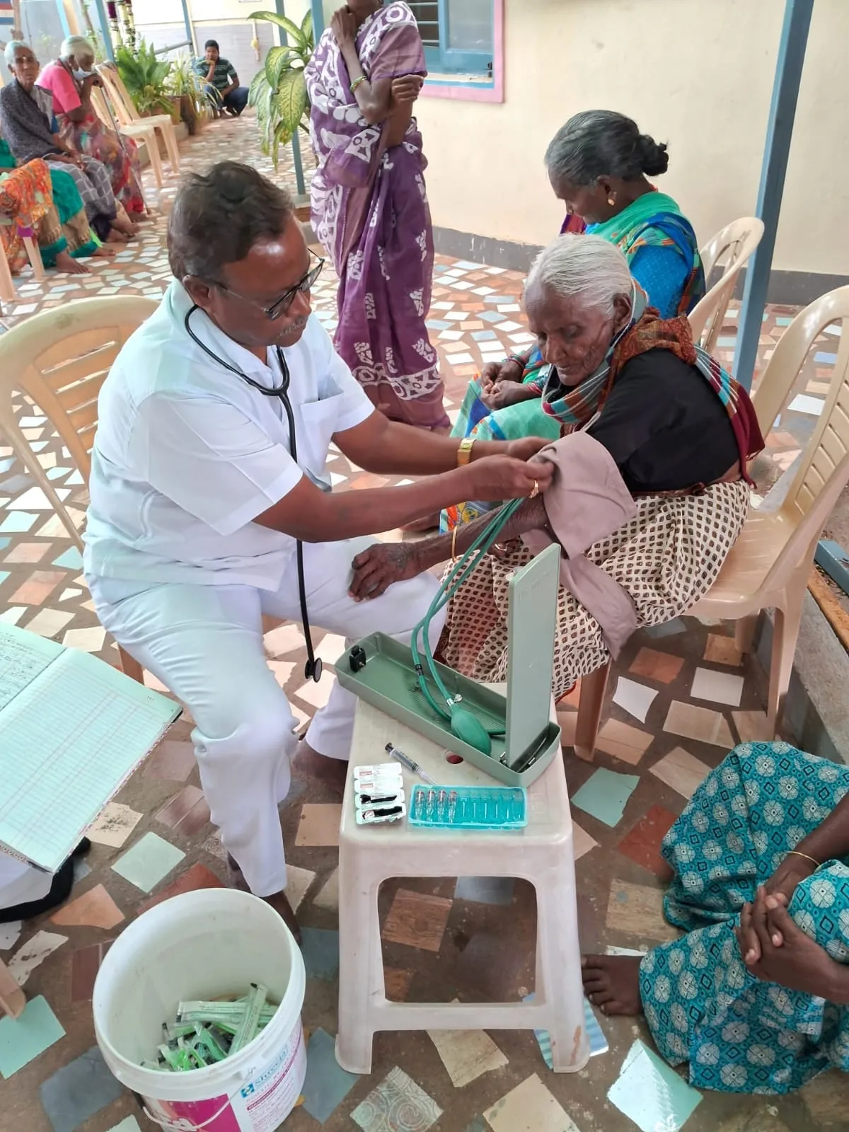 A nurse attending to an elderly woman at the camp