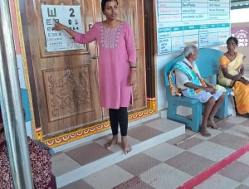 A volunteer visiting an elderly resident in a village near Puttaparthi