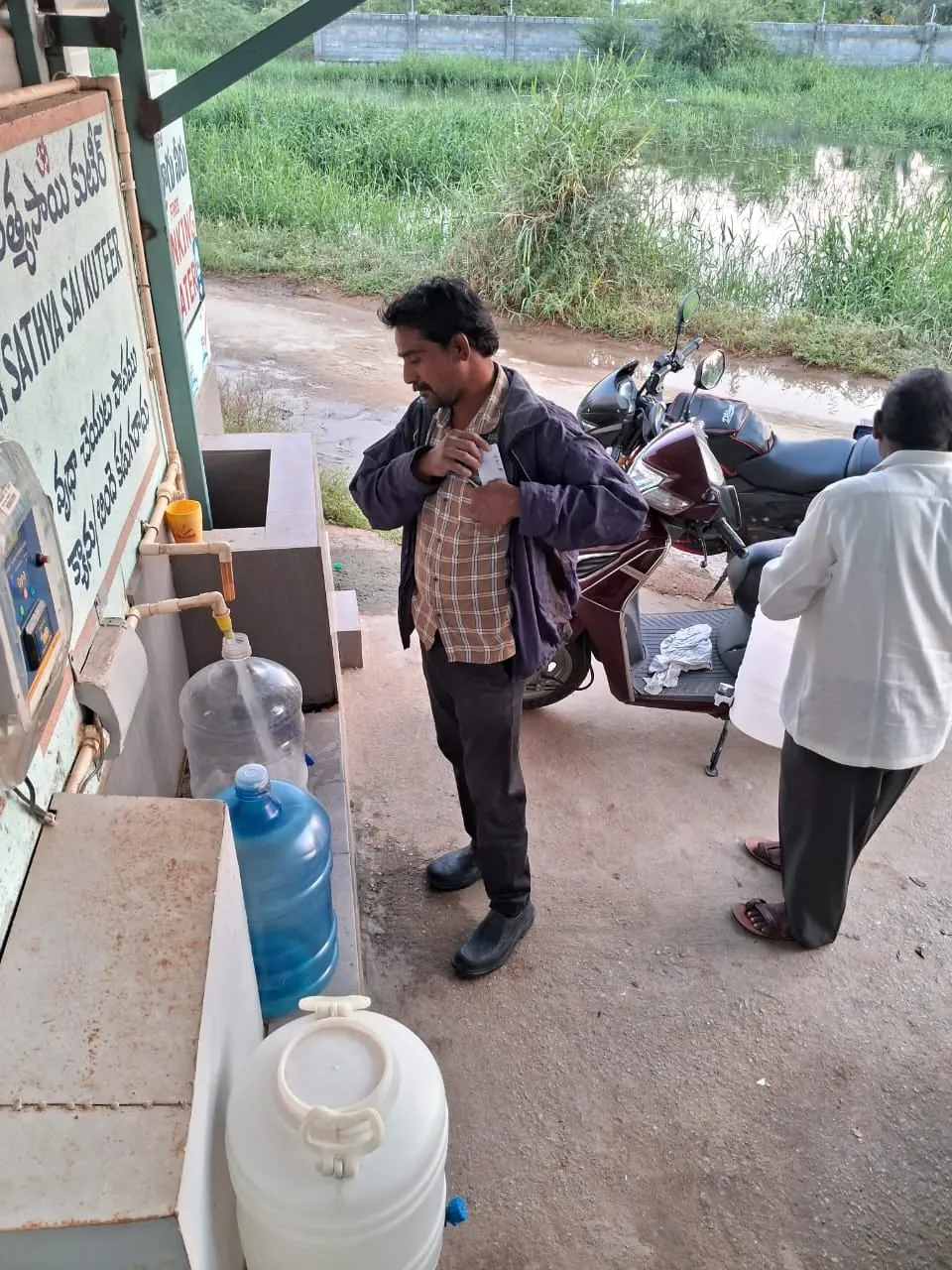 A resident loading a filled water can onto a scooter